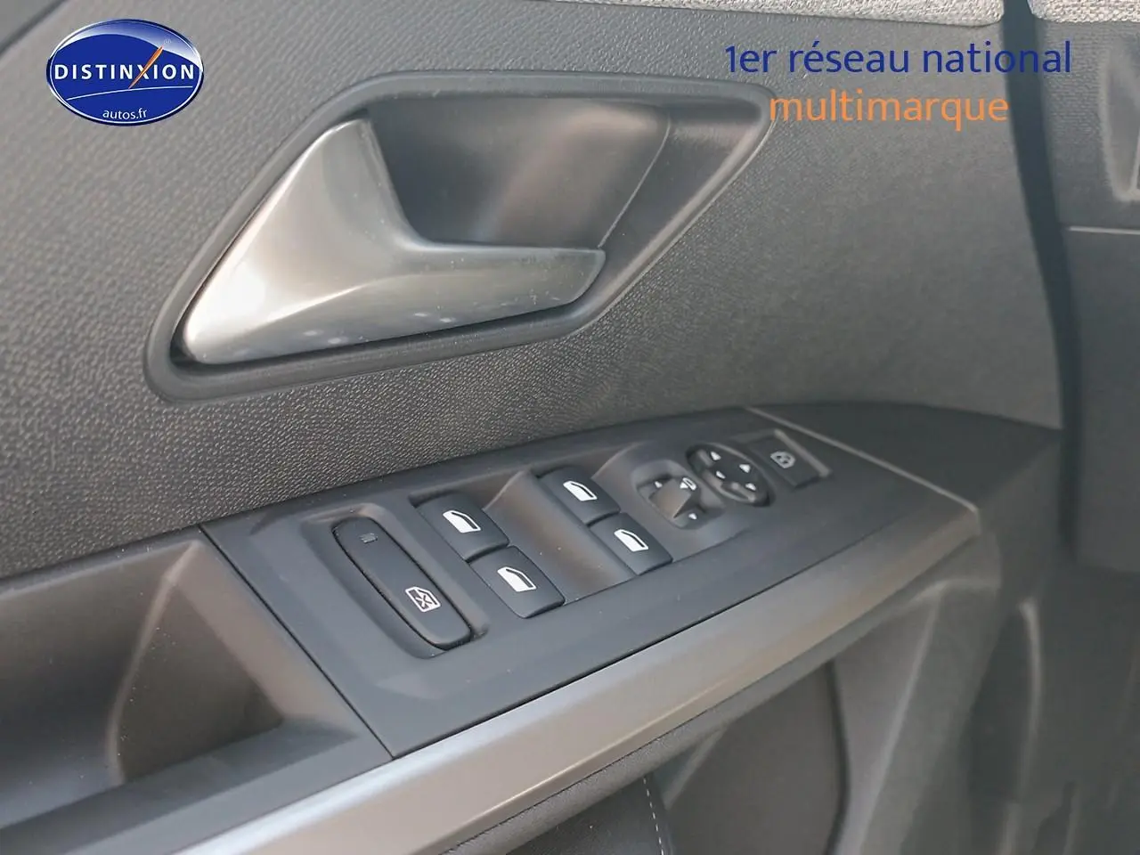 Gros plan sur les commandes des vitres et rétroviseurs côté conducteur d’un Peugeot 5008 gris artense.