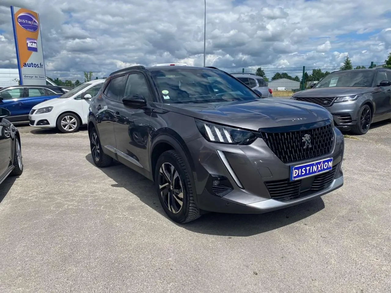Peugeot 2008 gris foncé en 3/4 avant droit, avec jantes alliage bi-tons et signature lumineuse LED distinctive.