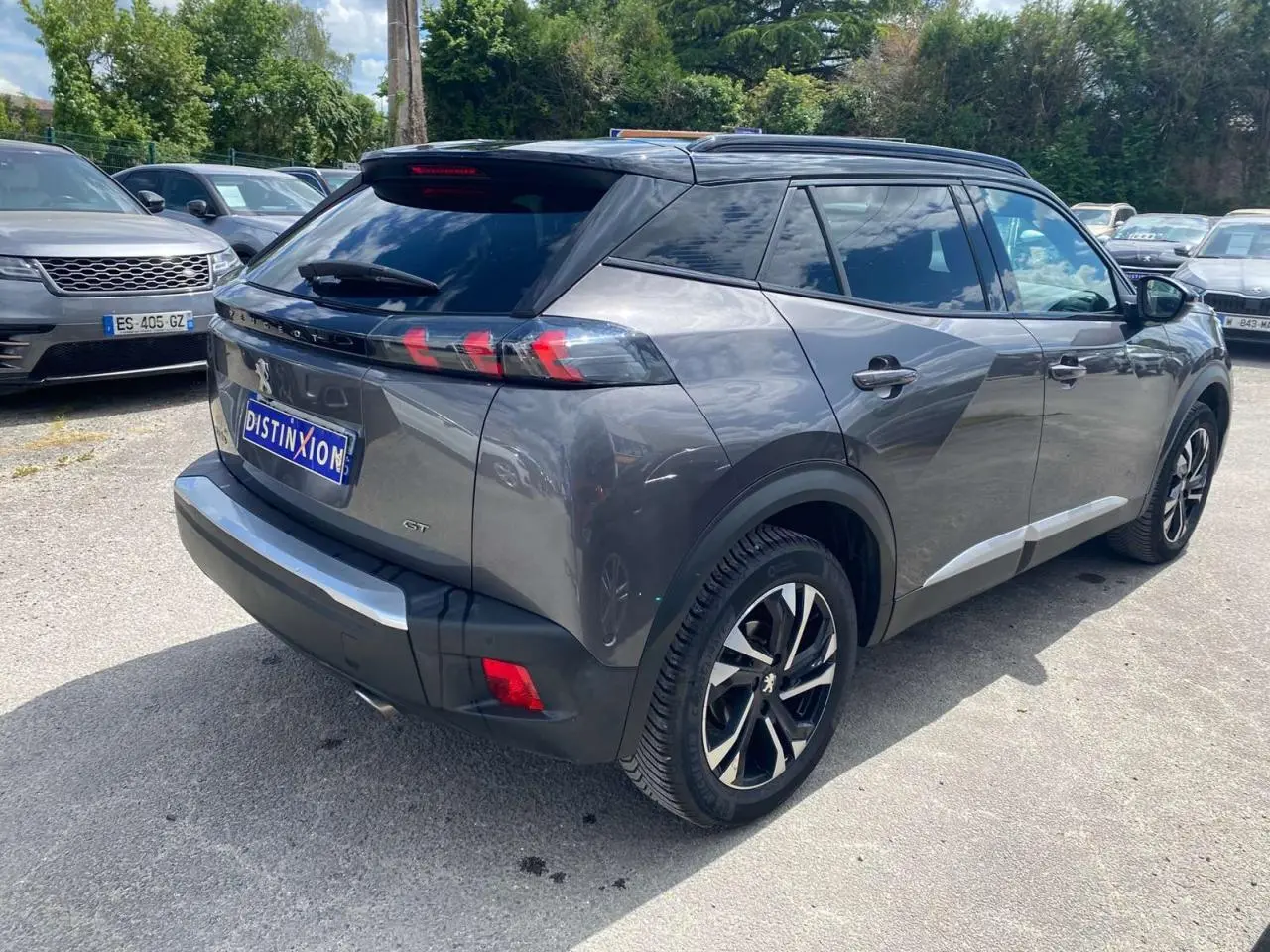 Peugeot 2008 gris foncé vue 3/4 arrière droit, avec jantes alliage bi-tons et toit noir brillant.