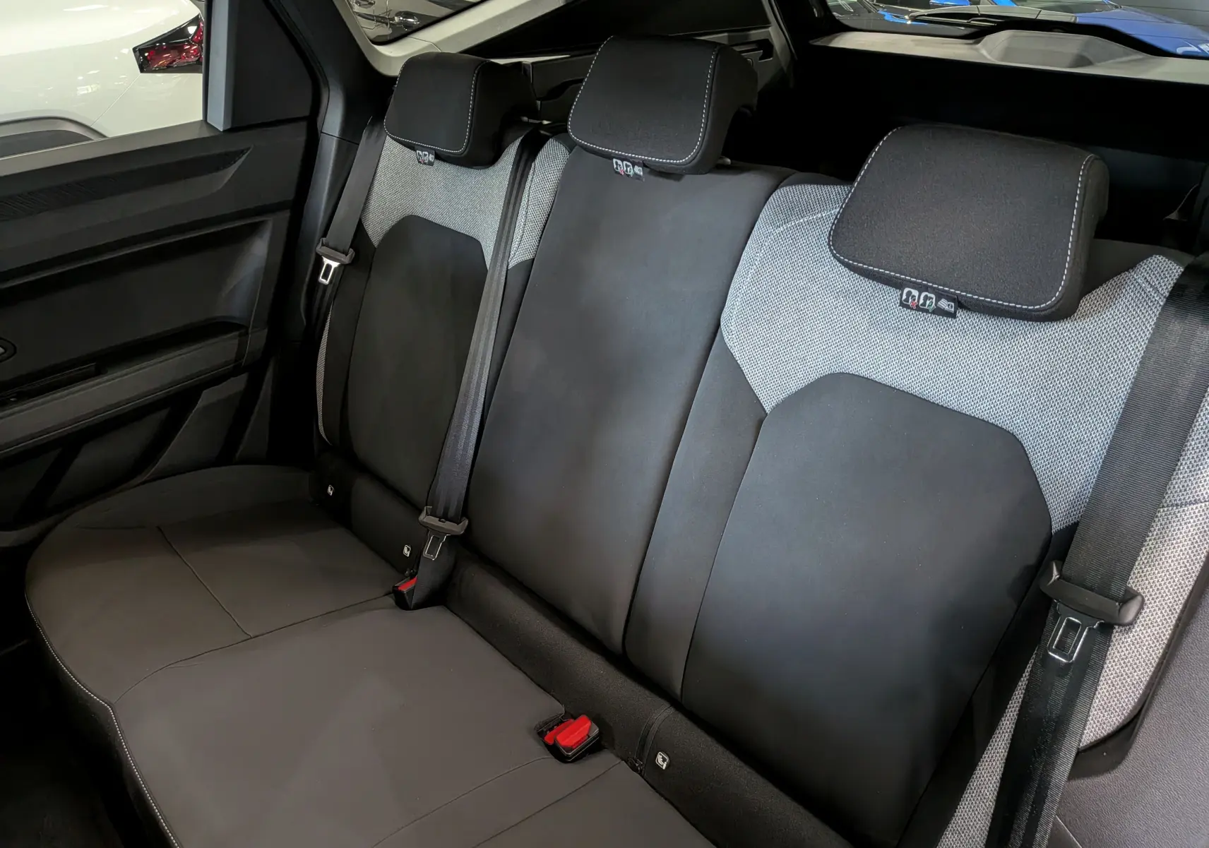 Vue intérieure des sièges arrière en tissu noir et gris du Dacia Bigster 2026, mettant en valeur les appuie-têtes et ceintures de sécurité.