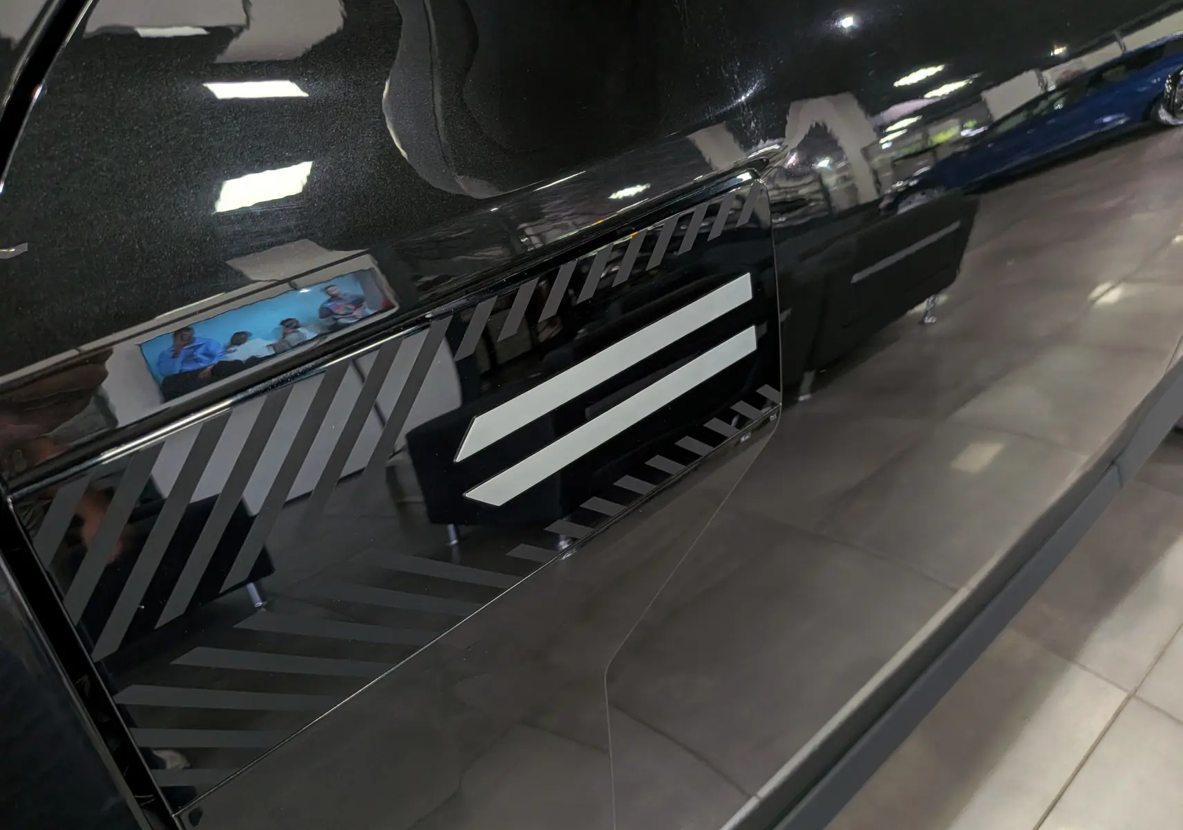 Détail du réservoir noir nacré du Dacia Bigster 2026 avec motif graphique en diagonale sur fond brillant.