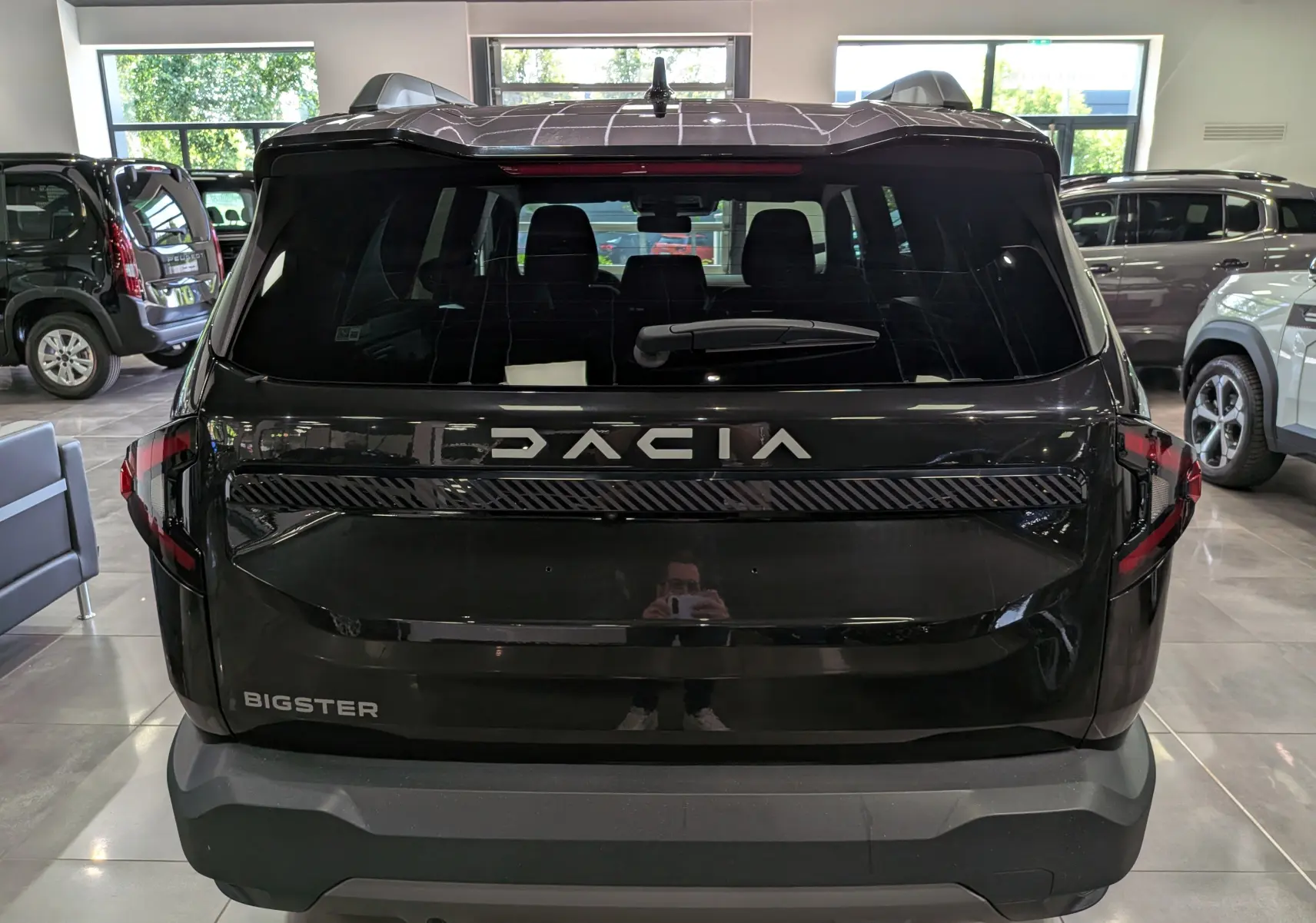 Vue arrière du Dacia Bigster noir nacré 2026 avec logo et feux arrière distinctifs en showroom.