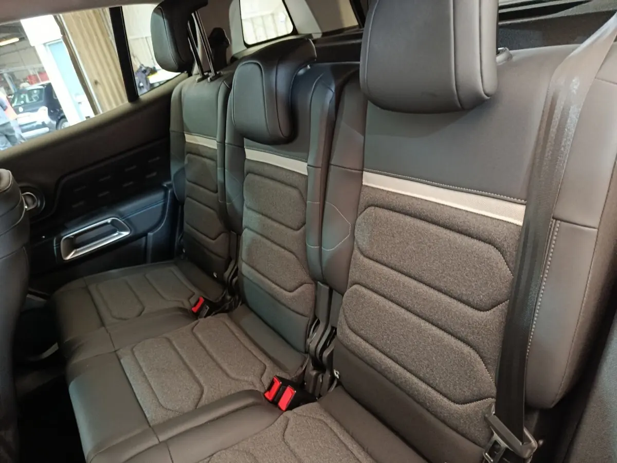 Vue intérieure du siège arrière droit du Citroën C5 Aircross 2024 noir, avec assises en tissu et cuir noir.