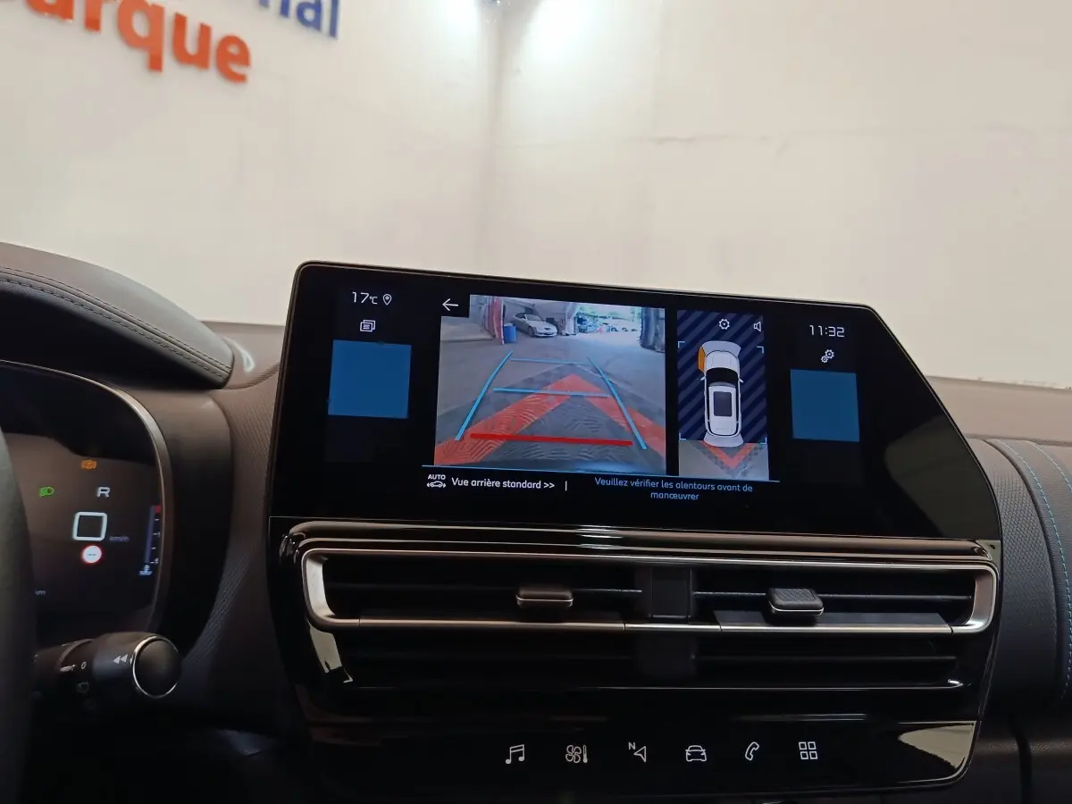 Vue intérieure du tableau de bord du Citroën C5 Aircross 2024 noir, écran tactile affichant la caméra de recul et l'aide au stationnement.