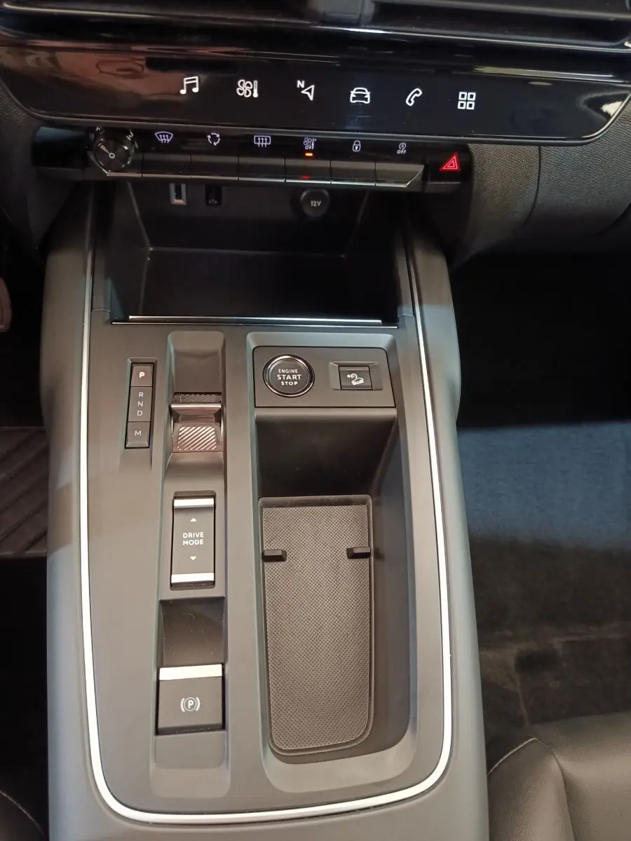 Vue plongeante sur la console centrale noire du Citroën C5 Aircross 2024 avec bouton start/stop et commandes de boîte automatique.