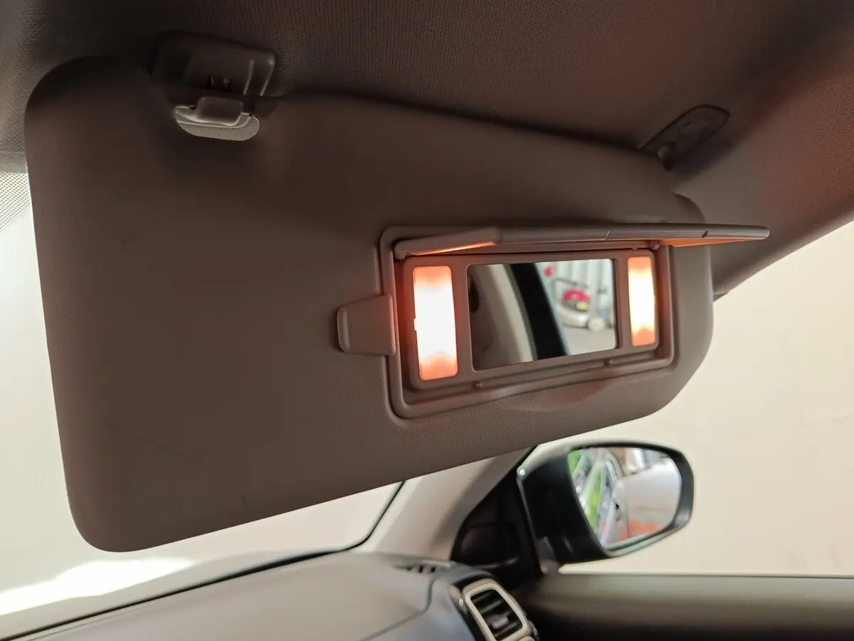 Détail intérieur du pare-soleil côté conducteur avec miroir éclairé, vue sur rétroviseur et tableau de bord noir du Citroën C5 Aircross.