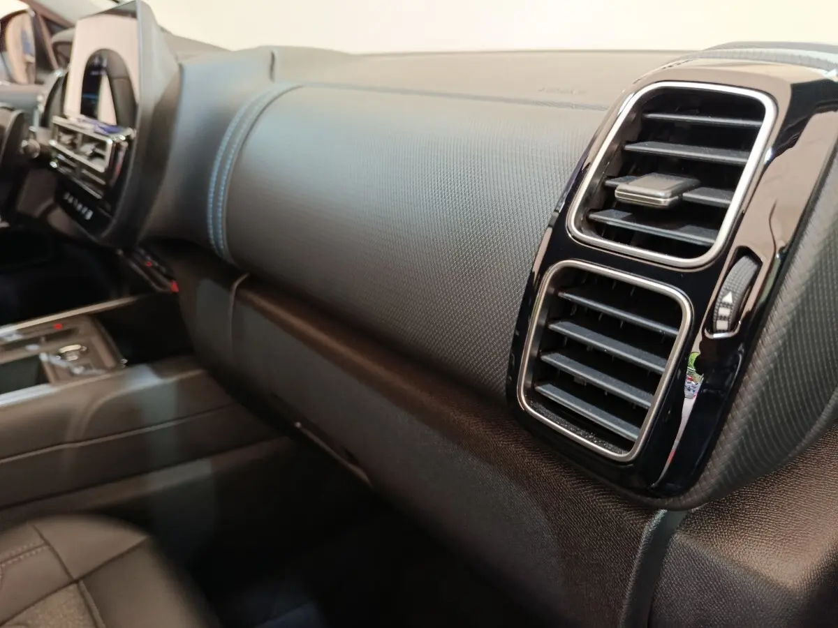 Vue intérieure du tableau de bord côté passager du Citroën C5 Aircross 2024 avec aérateurs noirs et surpiqûres bleues.