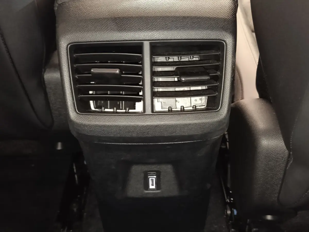 Vue rapprochée des aérateurs arrière noirs et prise USB du Citroën C5 Aircross 2024 côté console centrale.