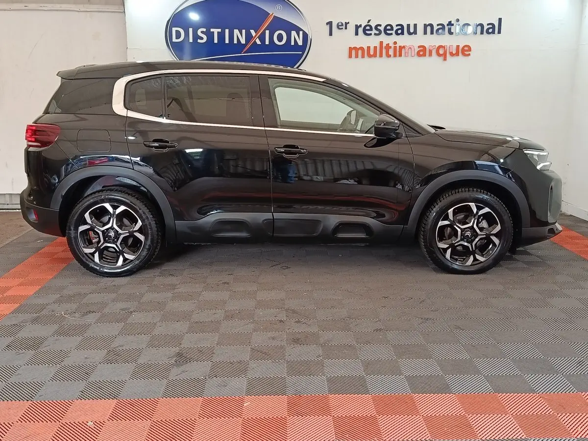 Vue de profil côté gauche d'un Citroën C5 Aircross noir 2024, avec jantes alliage et protections noires sur les bas de caisse.
