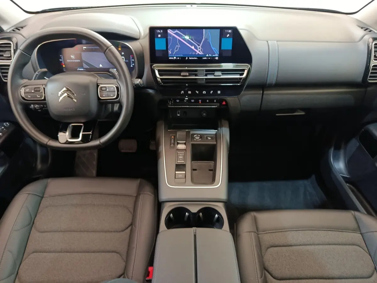 Vue intérieure avant du Citroën C5 Aircross 2024 noir, avec tableau de bord digital et écran tactile central.