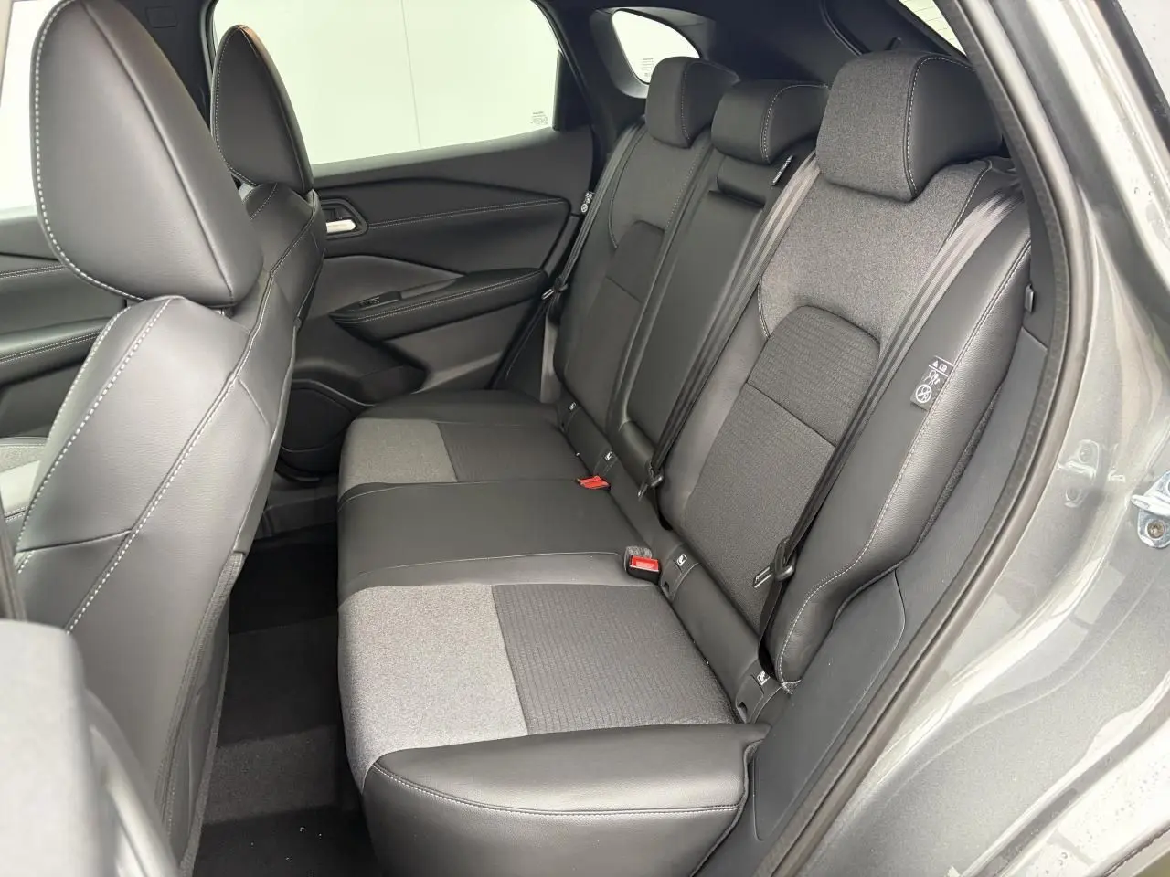 Vue latérale droite de la banquette arrière mixte tissu et TEP noire du Nissan Qashqai III 2025 couleur gris foncé métallisé.