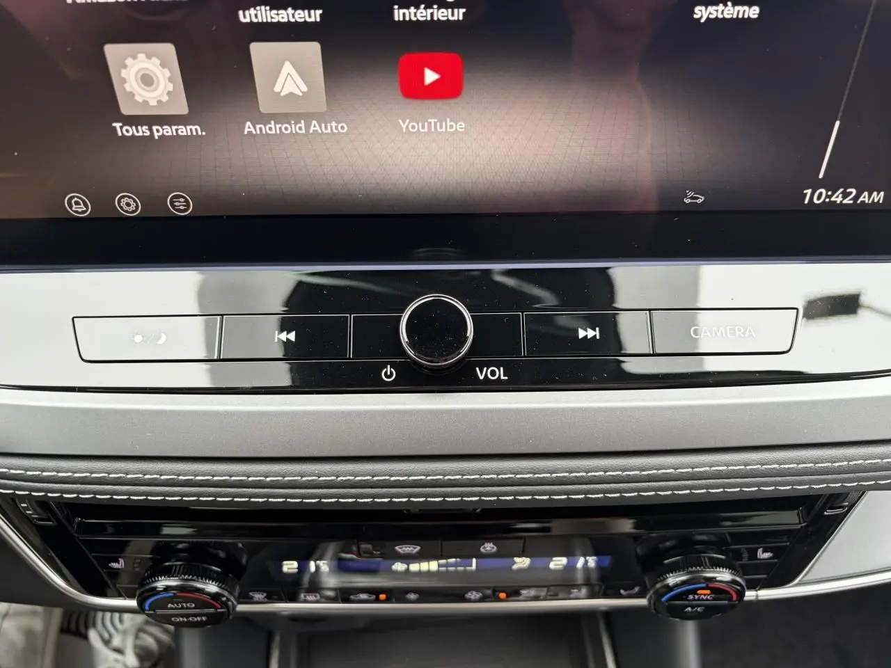 Détail de la console centrale avec commandes multimédia et climatisation du Nissan Qashqai III gris foncé.