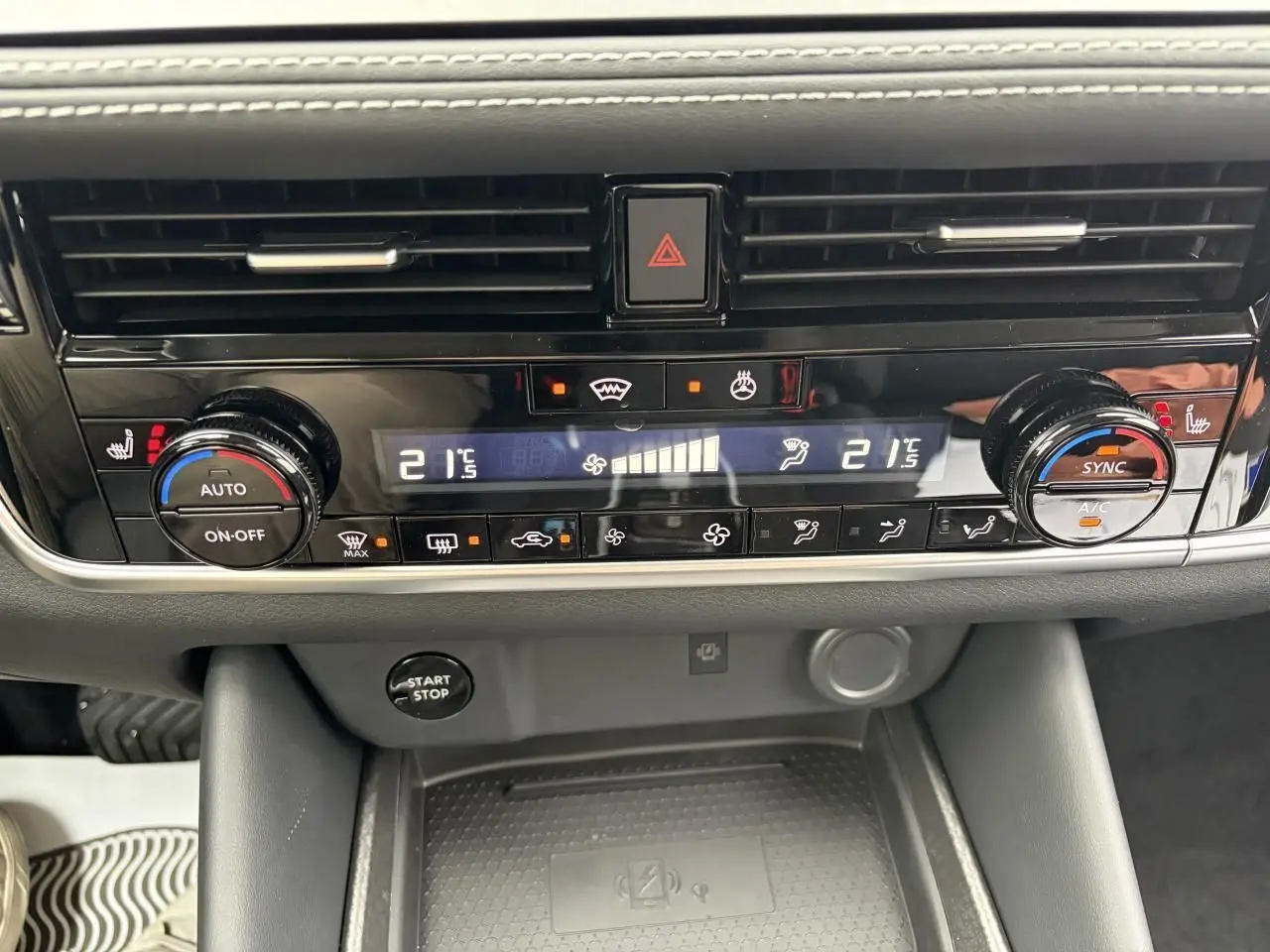 Vue rapprochée de la console centrale du Nissan Qashqai 2025, avec commandes climatisation automatique et bouton start/stop.