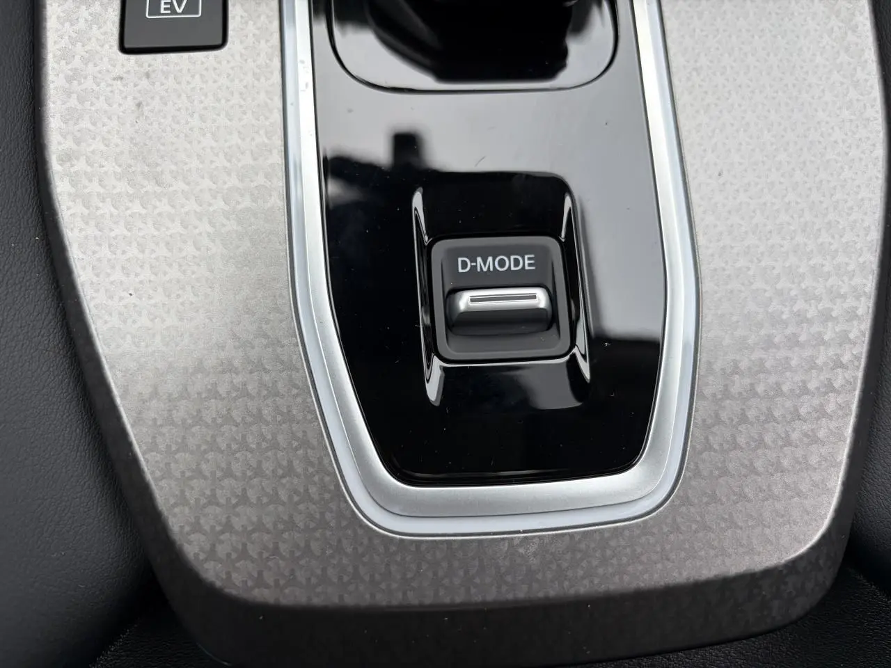 Gros plan sur la commande D-MODE au centre de la console du Nissan Qashqai III gris foncé.