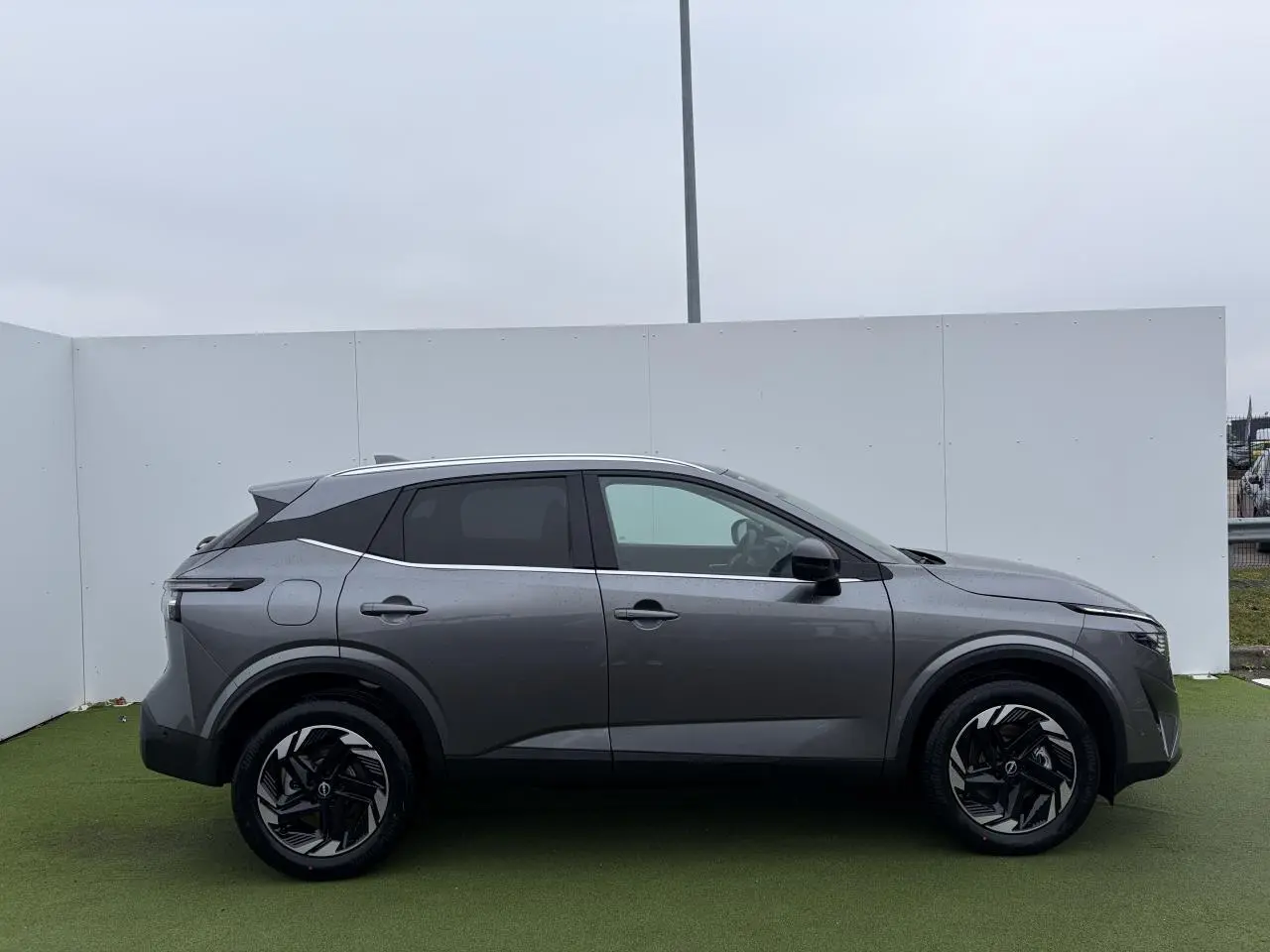 Profil droit du Nissan Qashqai III 1.5 Hybrid E-Power 2025 en gris foncé métallisé avec jantes alliage 18 pouces.