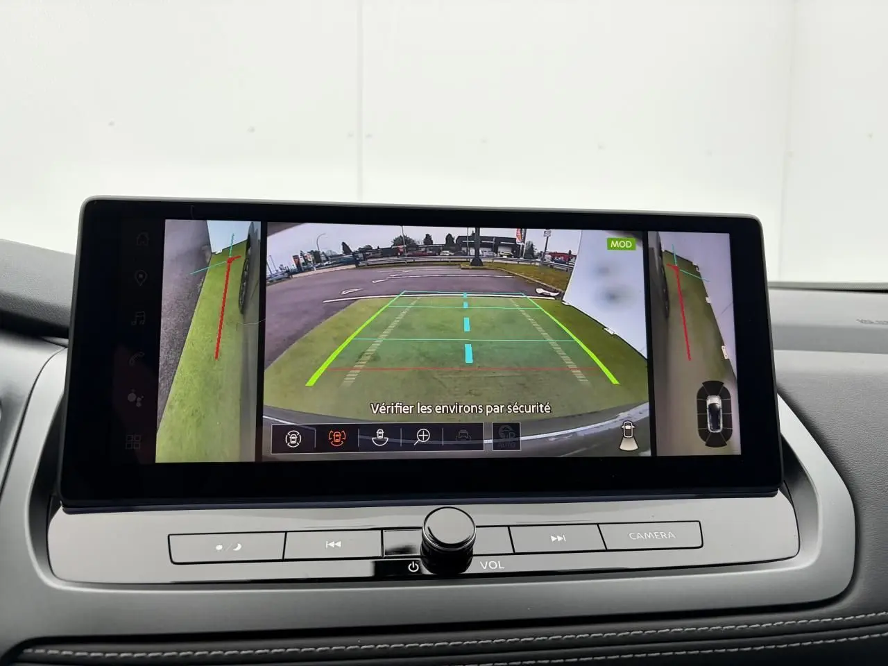 Écran central du Nissan Qashqai 2025 affichant la caméra de recul avec vues latérales et lignes de guidage colorées.