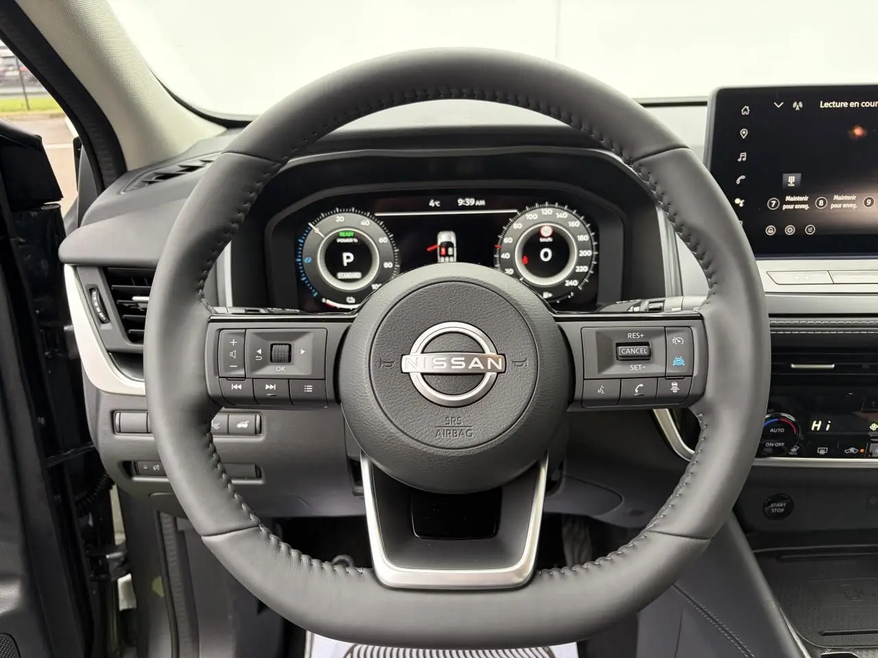 Vue frontale centrée sur le volant cuir noir du Nissan Qashqai III 2025 avec tableau de bord numérique et écran tactile.