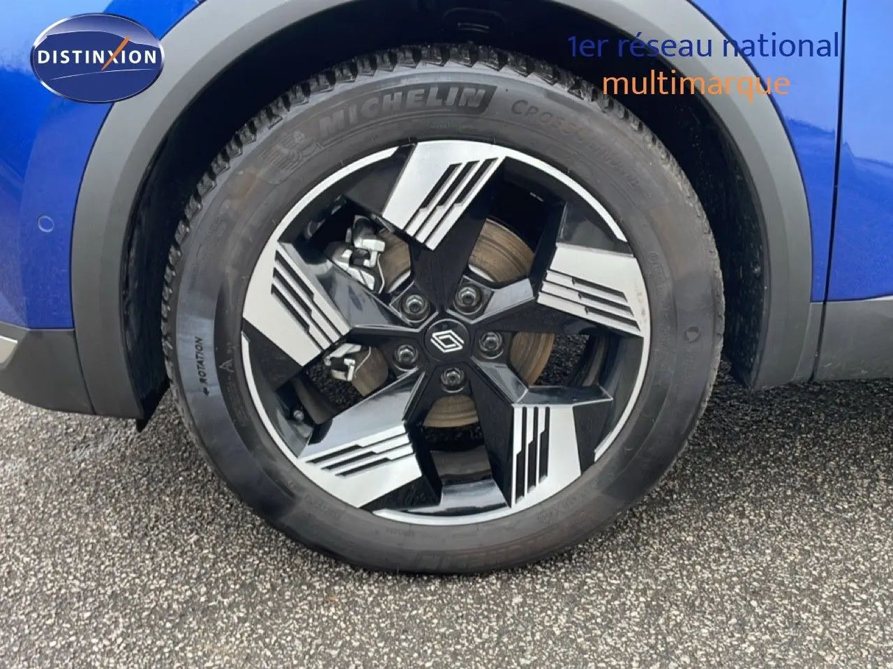 Gros plan sur la roue avant droite du Renault Symbioz 2025 en bleu Iron Metal avec jante alliage noire et argentée.