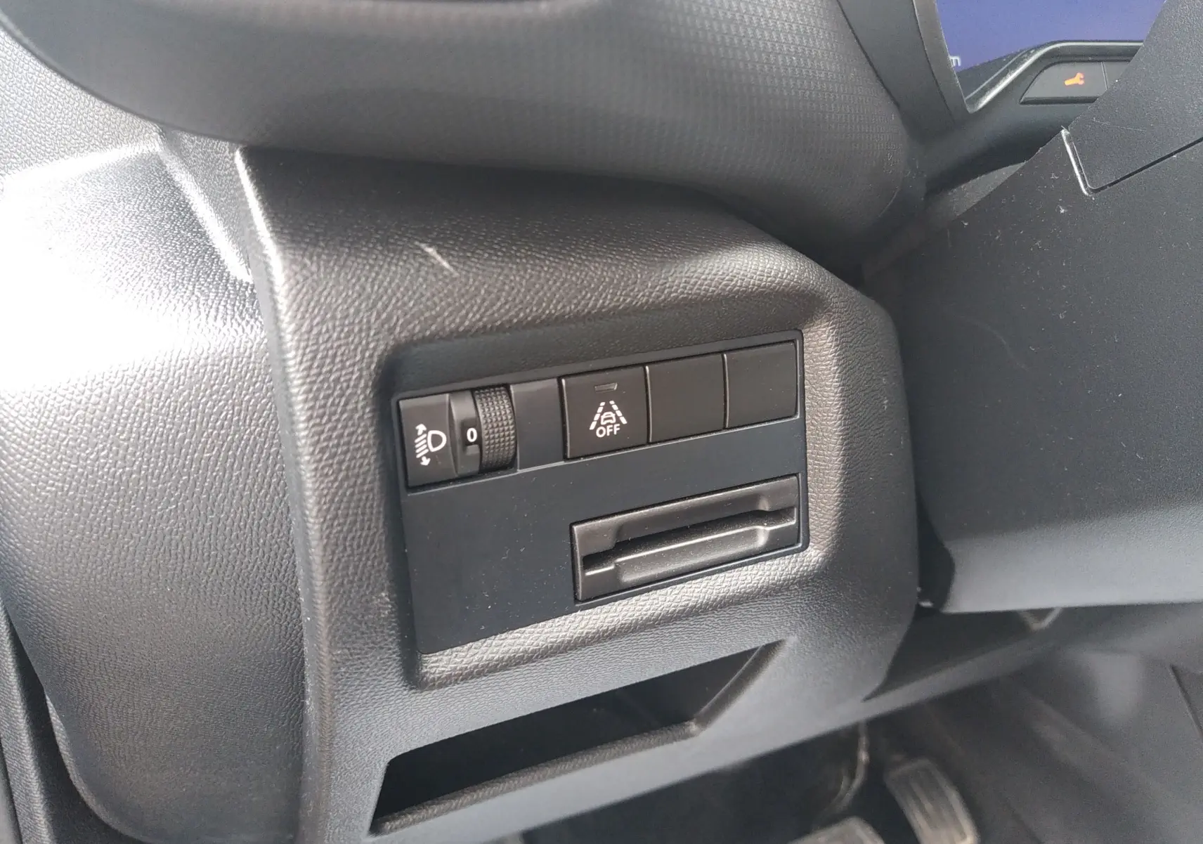 Détail intérieur côté gauche du tableau de bord du Citroën C5 Aircross 2023 avec commandes d'éclairage et d'aide à la conduite.
