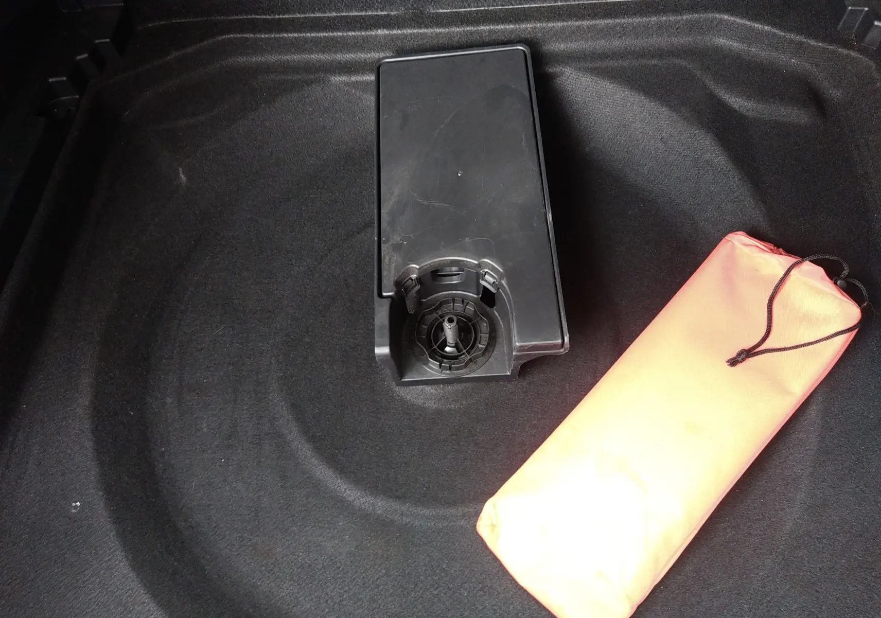 Gros plan sur le coffre du Citroën C5 Aircross 2023 montrant le rangement sous plancher avec trousse de secours orange.