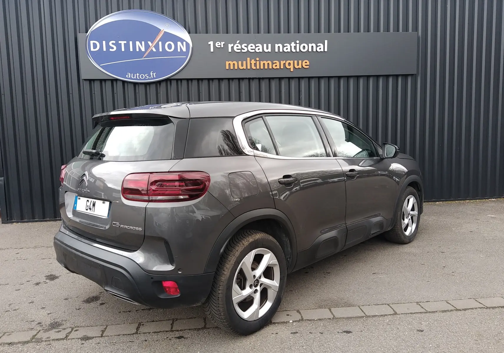 Vue 3/4 arrière droite d'un Citroën C5 Aircross gris platinium avec jantes alliage et protections latérales noires.