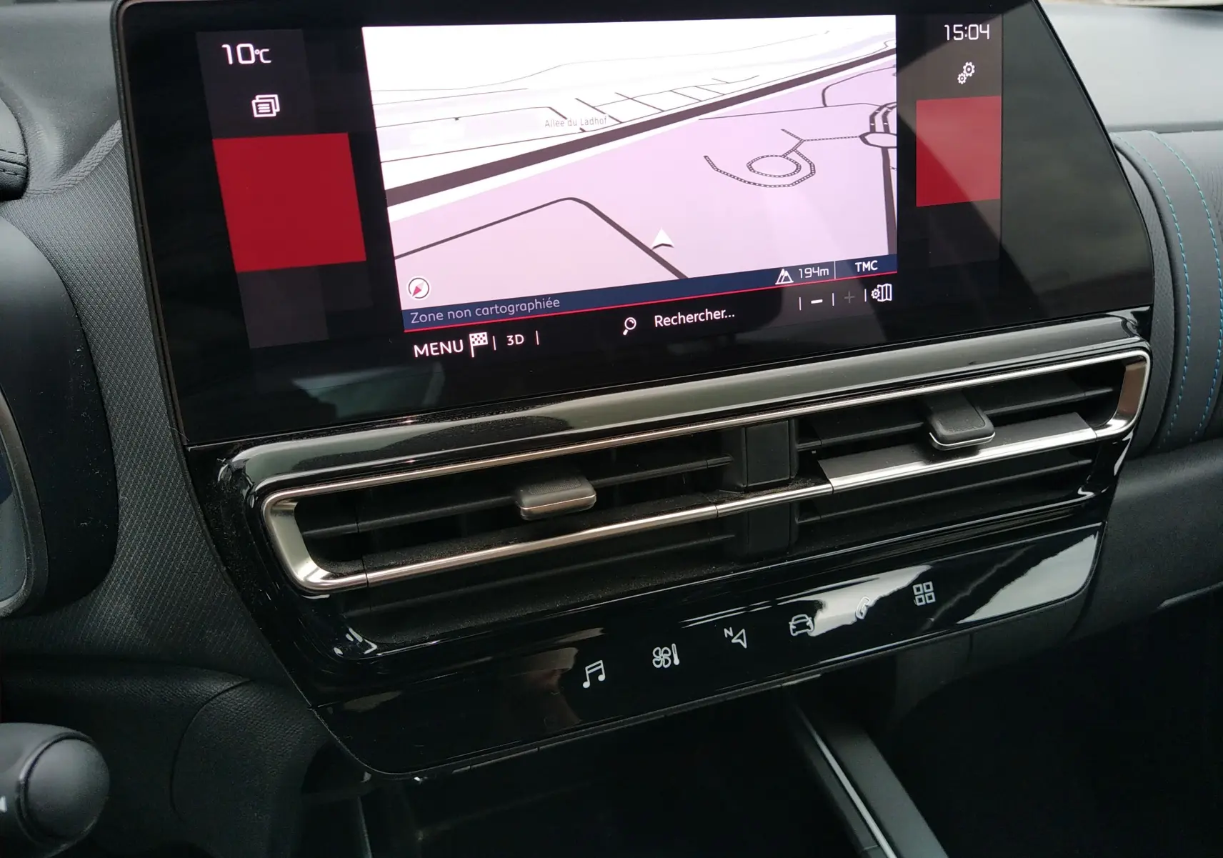 Gros plan sur l’écran tactile central et la console noire brillante du tableau de bord du Citroën C5 Aircross gris platinium 2023.