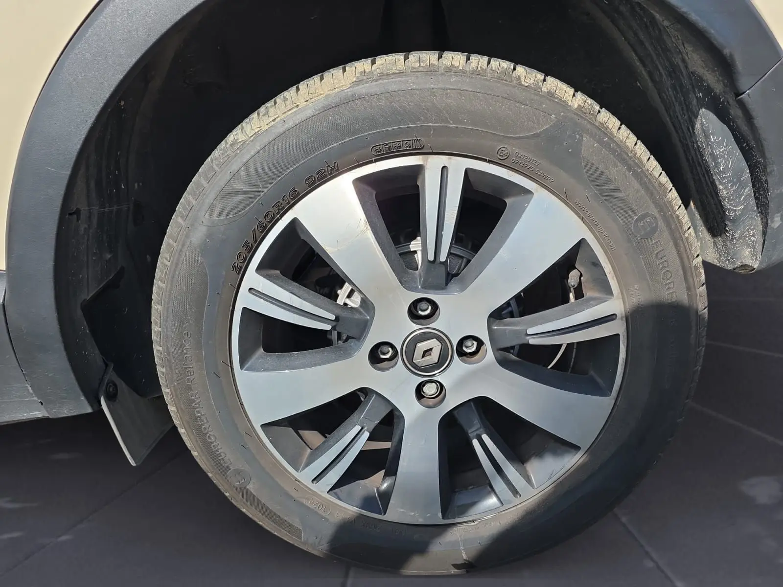 Vue rapprochée de l’écran tactile et des commandes de climatisation du tableau de bord noir du Renault Captur ivoire 2018.