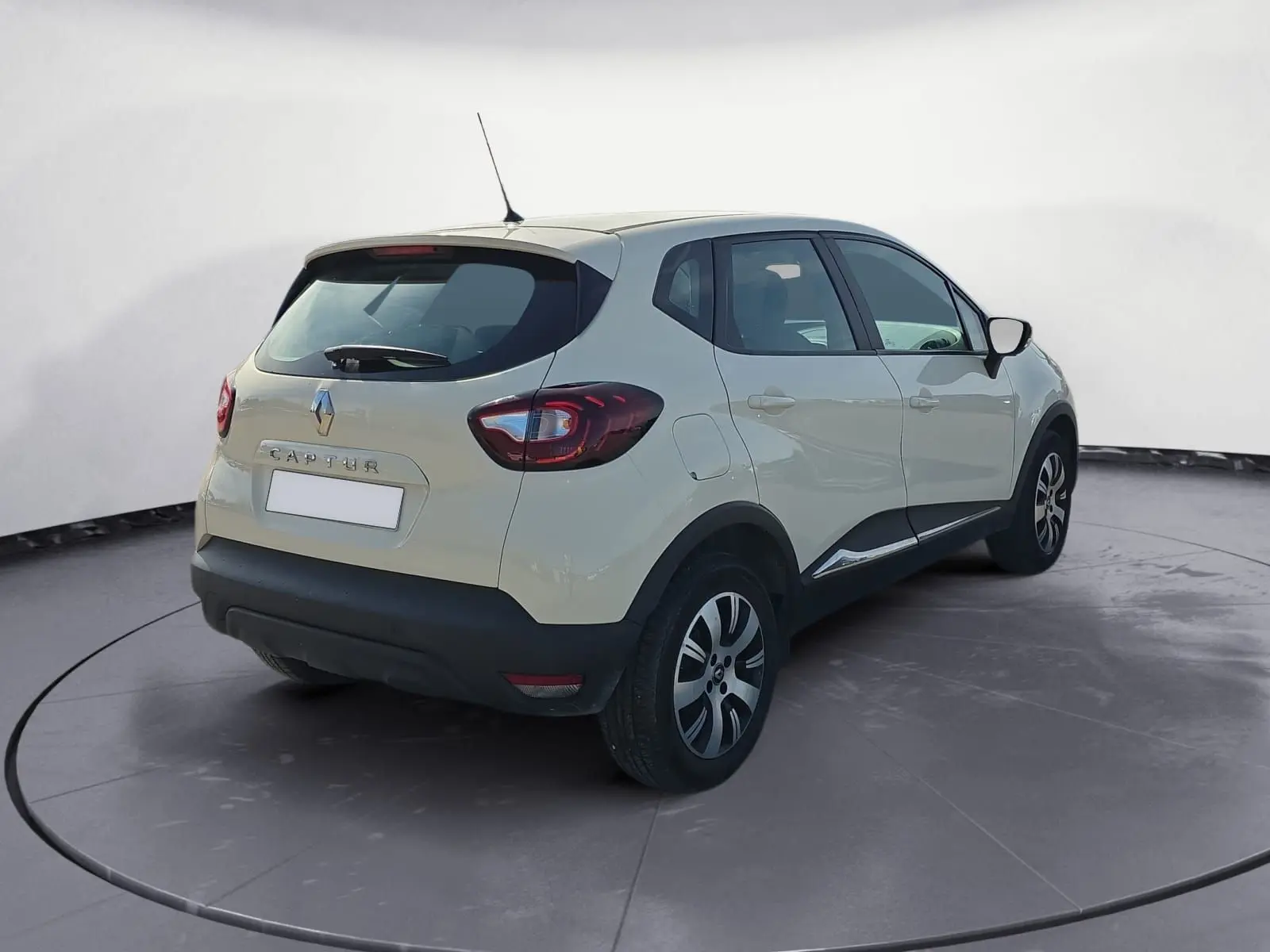 Vue arrière ouverte du coffre d'un Renault Captur ivoire 2018, mettant en valeur l'espace de chargement vide.