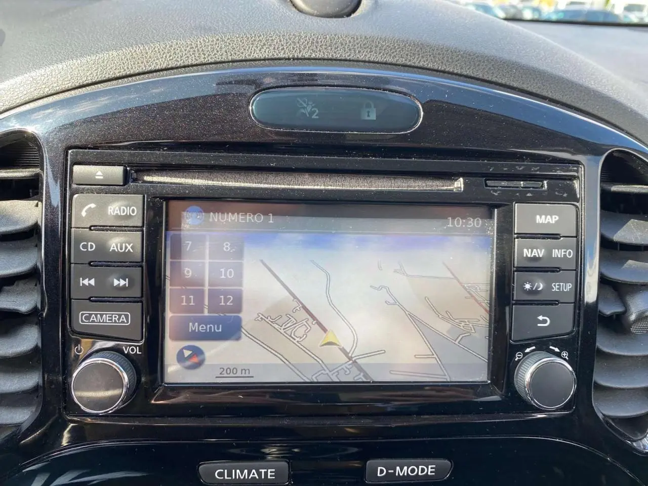Vue rapprochée de l’écran central du Nissan Juke blanc de 2017, affichant le GPS avec commandes autour.