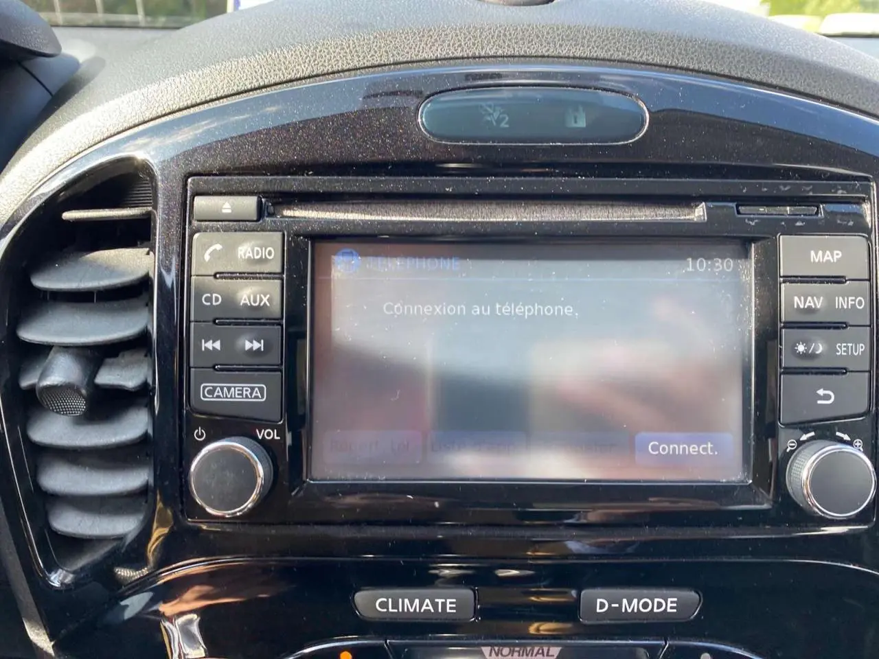 Gros plan sur le tableau de bord noir du Nissan Juke 2017, écran tactile affichant la connexion téléphone.