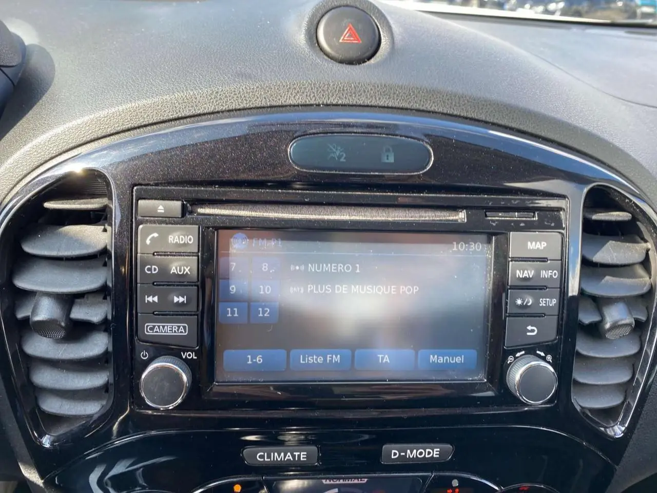 Vue rapprochée du tableau de bord noir du Nissan Juke 2017, avec écran tactile et commandes autour.