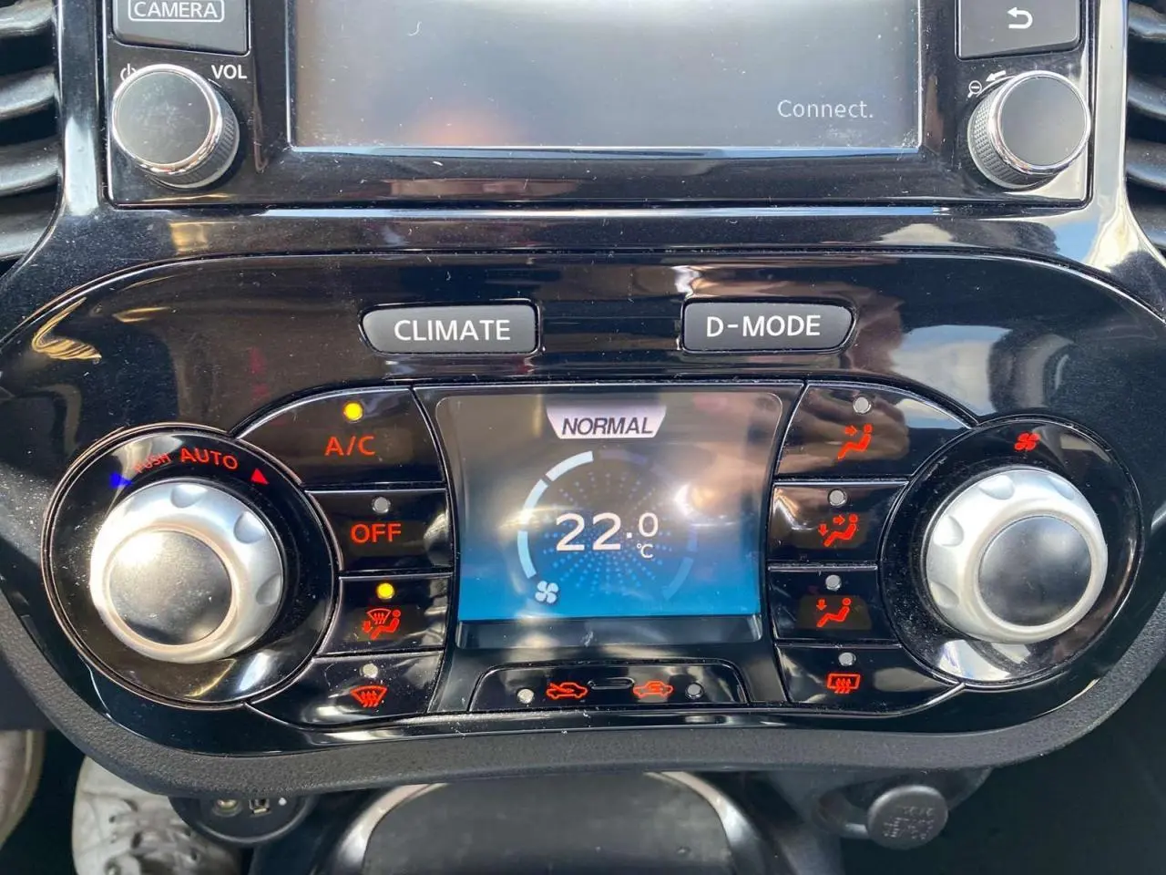 Vue rapprochée de la console centrale du Nissan Juke 2017, affichant la climatisation automatique réglée à 22°C.