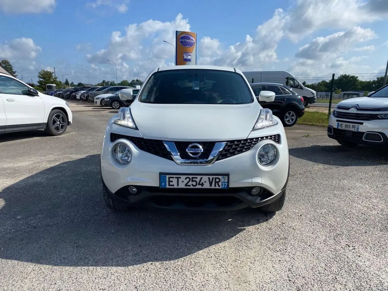 Vue avant d'un Nissan Juke blanc métallisé avec calandre chromée et phares ronds distinctifs.