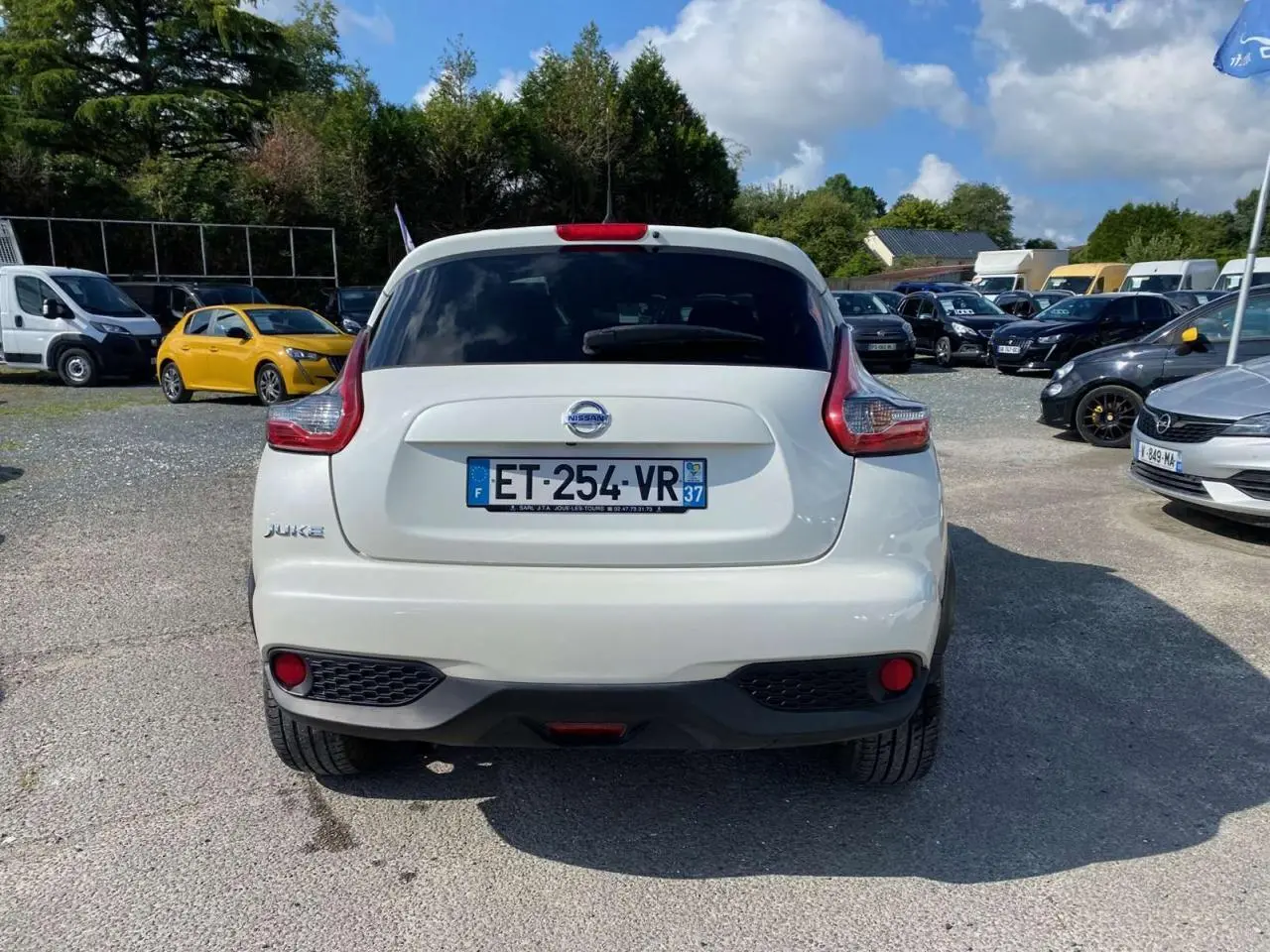 Vue arrière d'un Nissan Juke blanc avec feux arrière caractéristiques et plaque d'immatriculation française visible.
