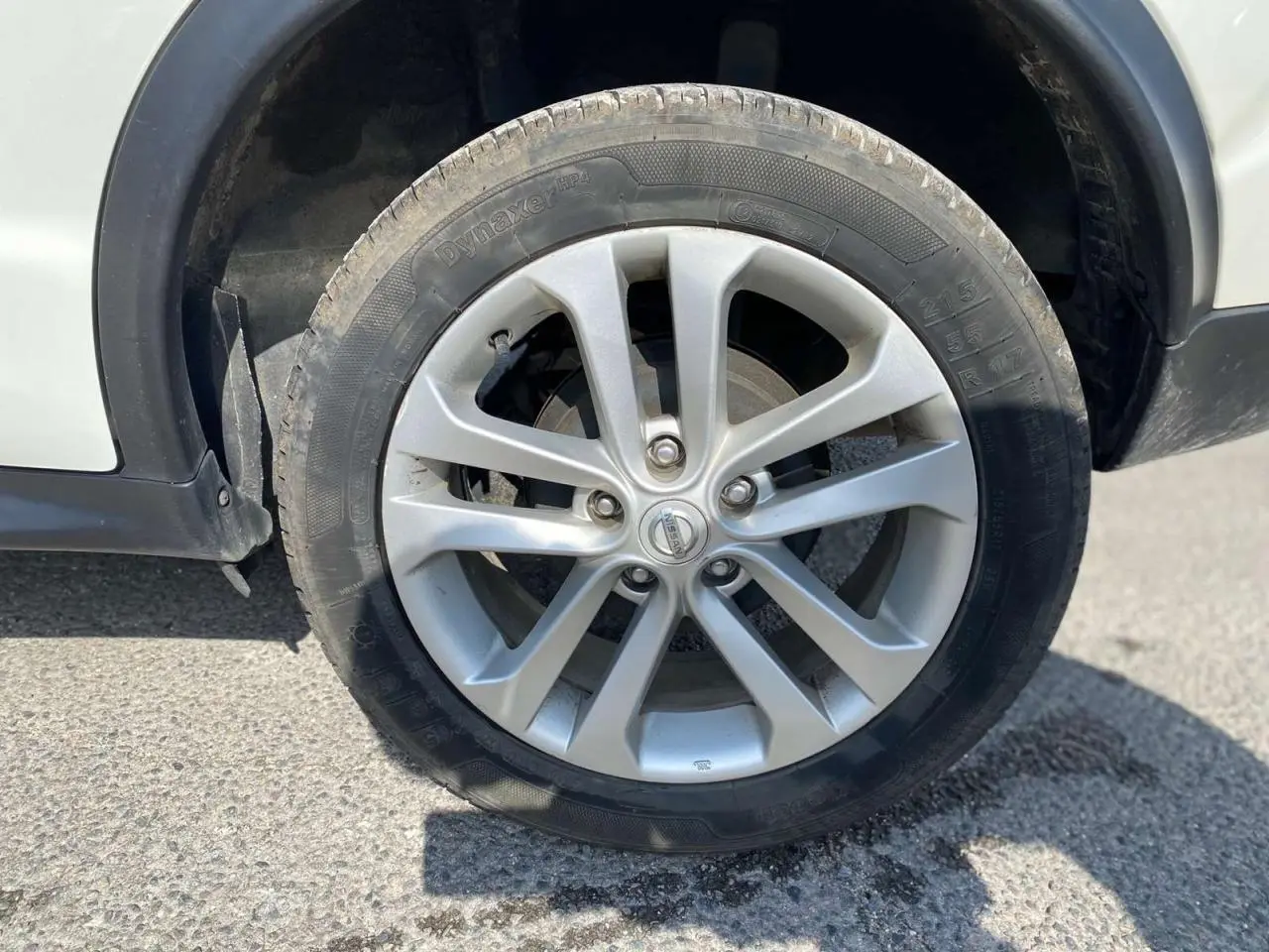 Gros plan sur la jante alliage 17 pouces argentée du côté avant droit d'un Nissan Juke blanc.