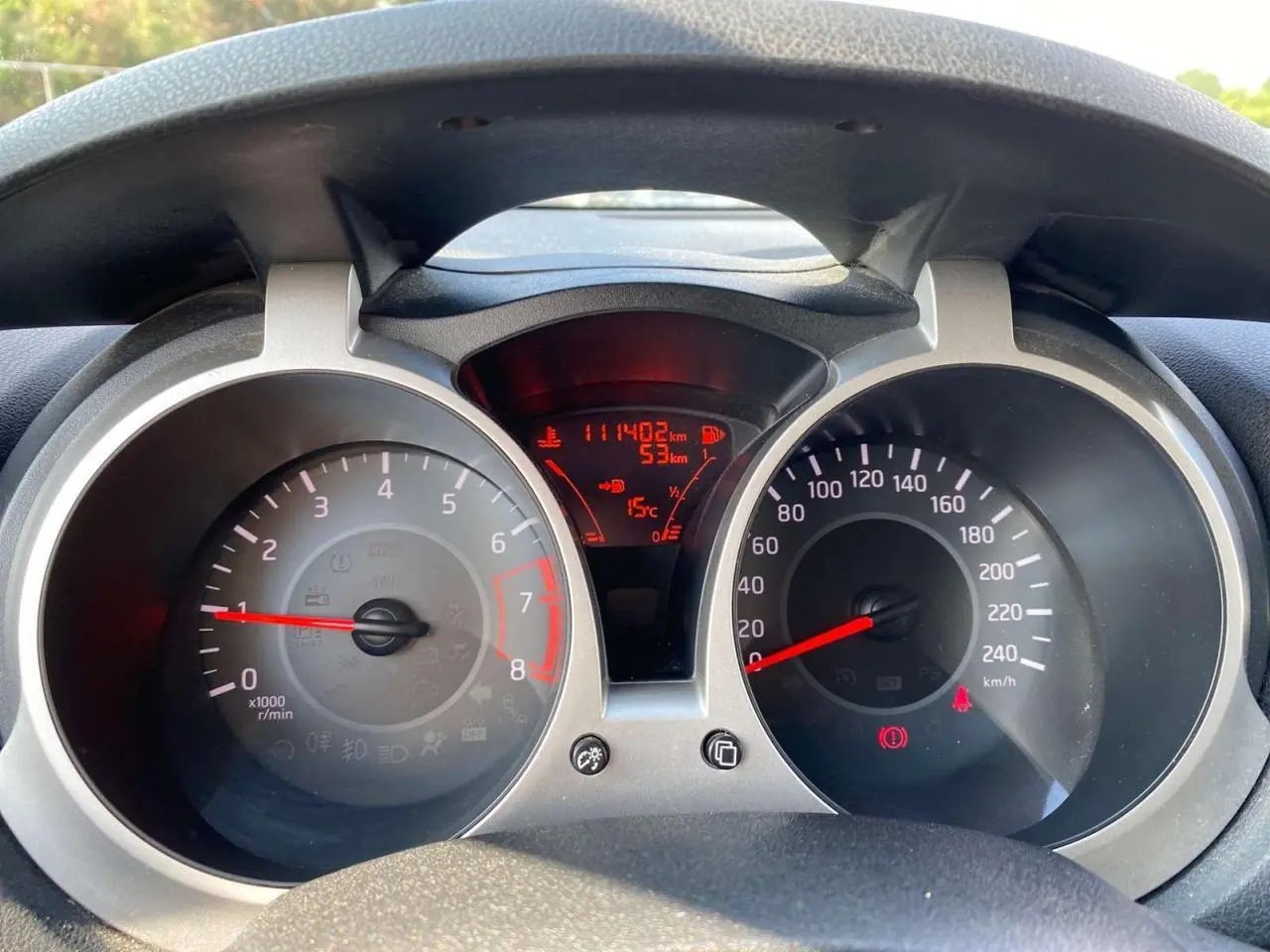 Vue rapprochée du tableau de bord du Nissan Juke blanc, affichant le compteur de vitesse et le compte-tours.