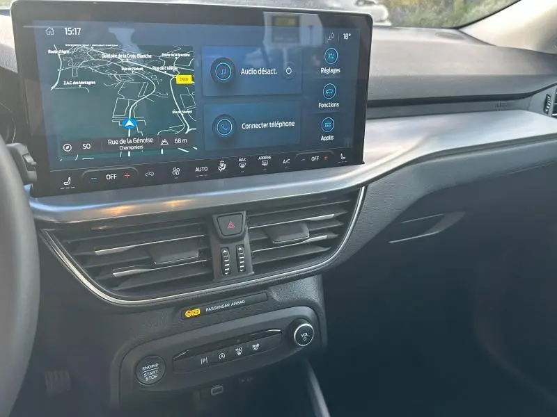 Vue intérieure du tableau de bord de la Ford Focus 2023, écran tactile central avec navigation et commandes climatisation.
