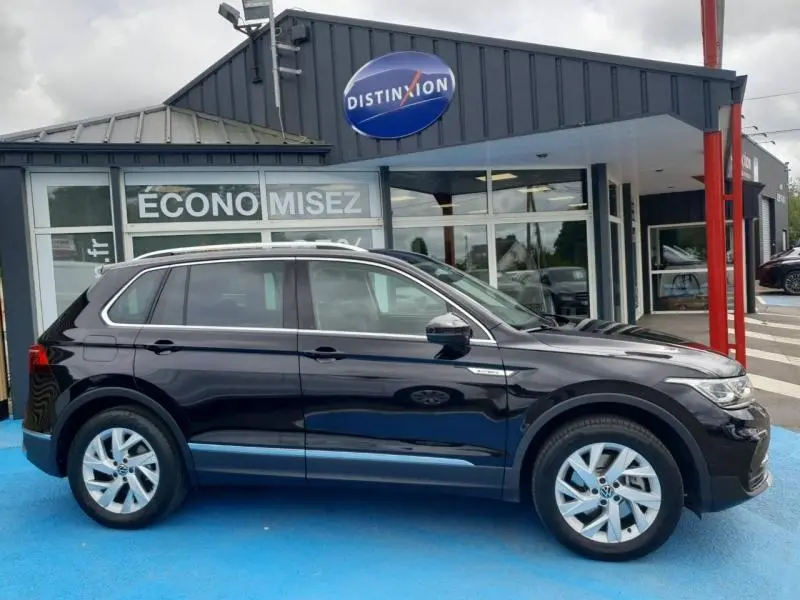 Vue latérale droite du Volkswagen Tiguan 1.4 eHybrid 245ch Elegance noir intense nacré avec jantes alu et barres de toit.