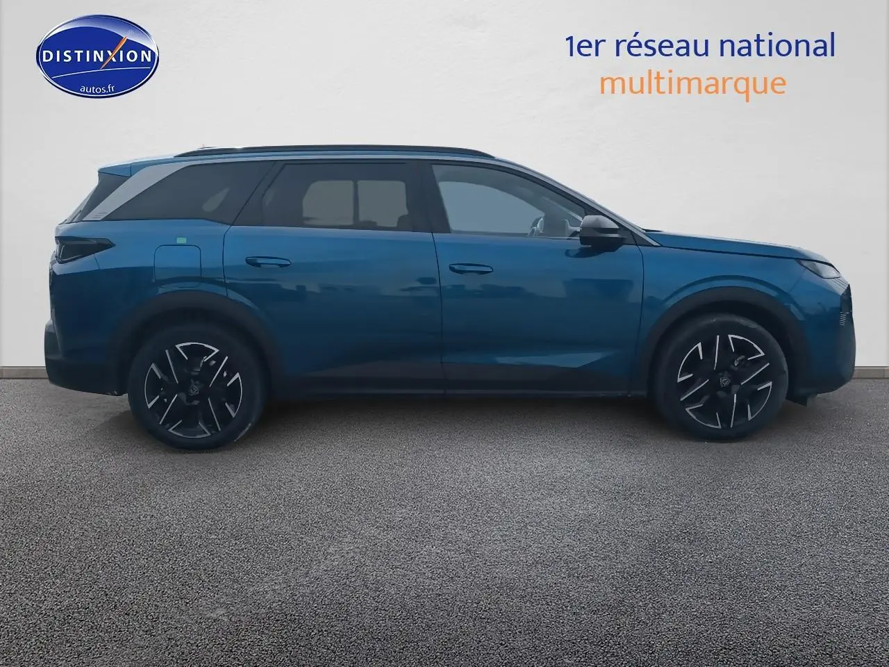 Profil côté gauche du Peugeot 5008 Hybrid 145 allure bleu 2025 avec jantes alu et vitres surteintées.