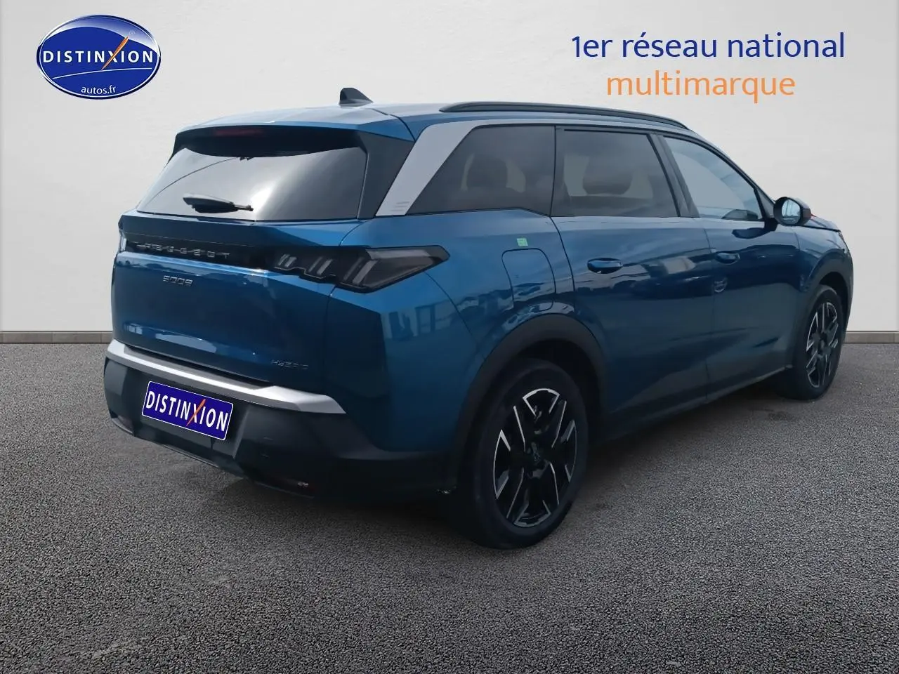 Vue 3/4 arrière droite d’un Peugeot 5008 Hybrid 145 allure e-dcs6 bleu avec jantes alu et toit noir.