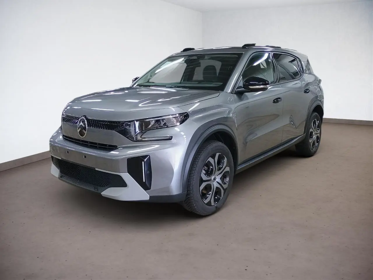 Citroën C3 Aircross Hybrid gris Mercury en 3/4 avant droit, avec jantes spécifiques et barres de toit noires.