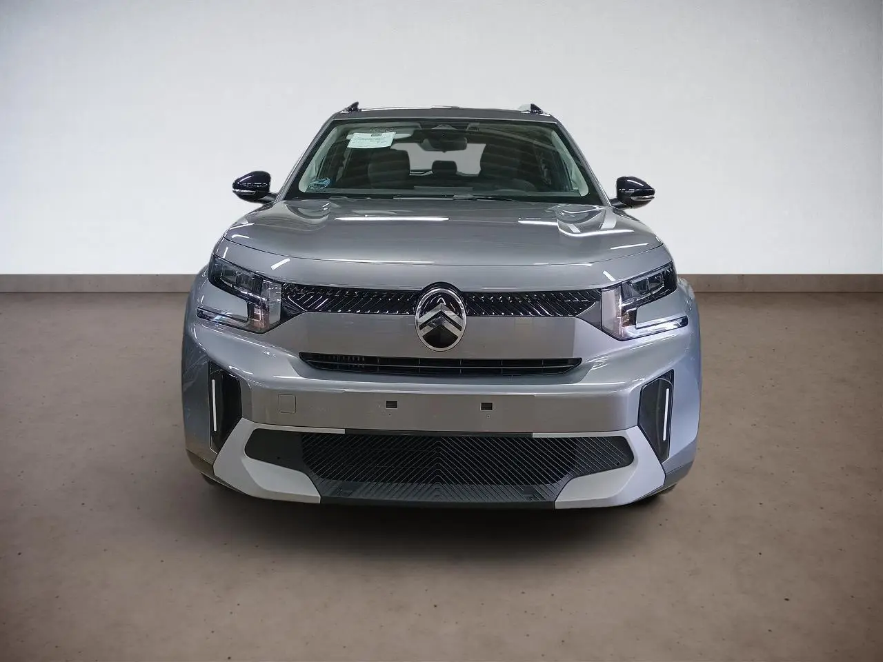Vue frontale d'un Citroën C3 Aircross 2025 gris Mercury avec calandre noire et phares LED distinctifs.