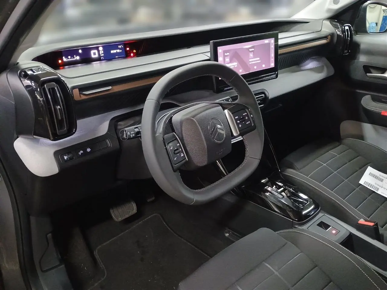 Vue intérieure côté conducteur du Citroën C3 Aircross 2025, tableau de bord moderne avec écran tactile et volant multifonctions.