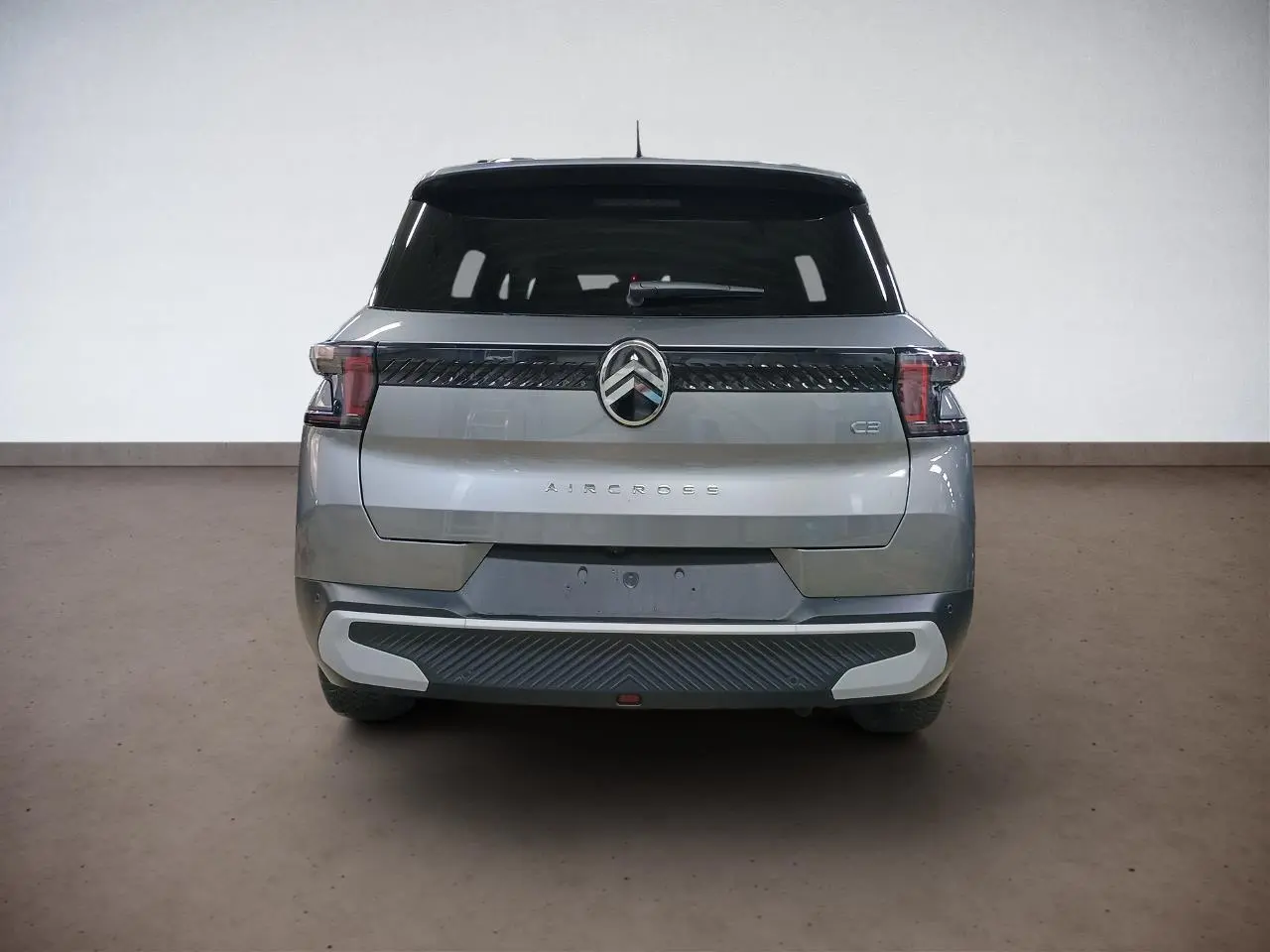 Vue arrière d'un Citroën C3 Aircross 2025 gris Mercury avec feux LED et logo chromé central.