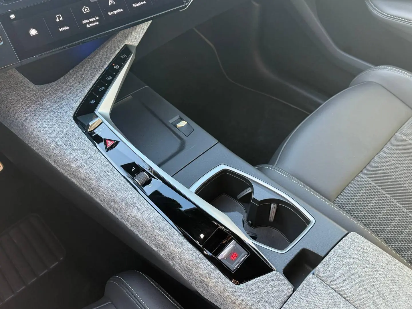 Vue intérieure en plongée sur la console centrale et siège avant droit gris clair du Peugeot 5008 Hybrid 2025.