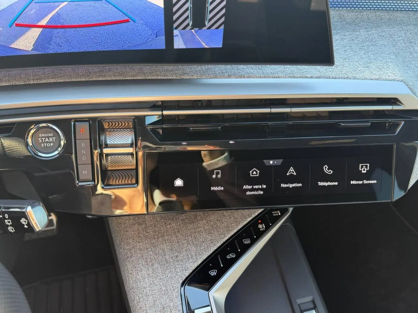 Vue rapprochée du tableau de bord du Peugeot 5008 blanc, montrant l’écran tactile et la commande de boîte automatique.