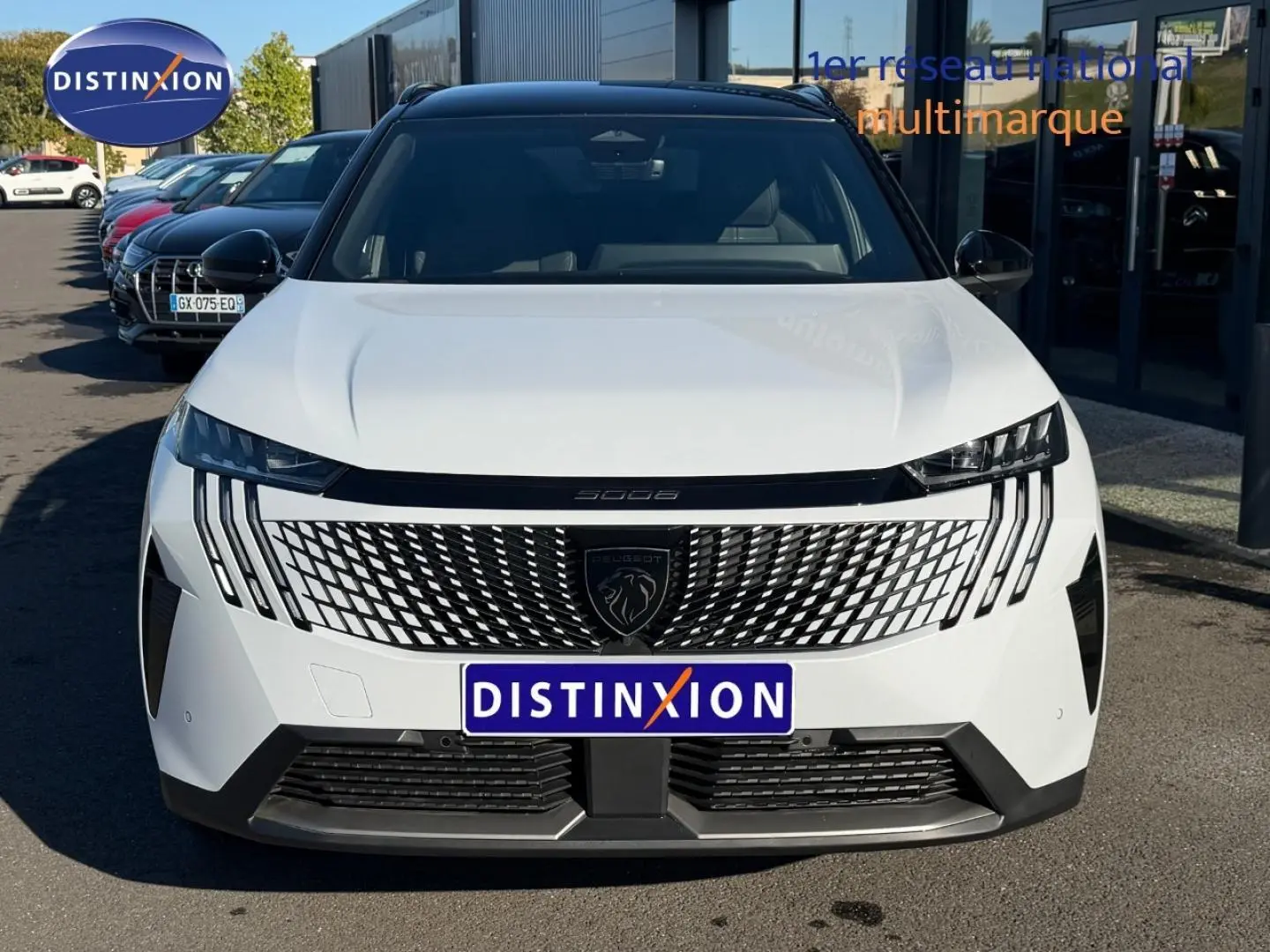 Vue frontale du Peugeot 5008 Hybrid blanc Okénite avec calandre distinctive et phares LED fins.