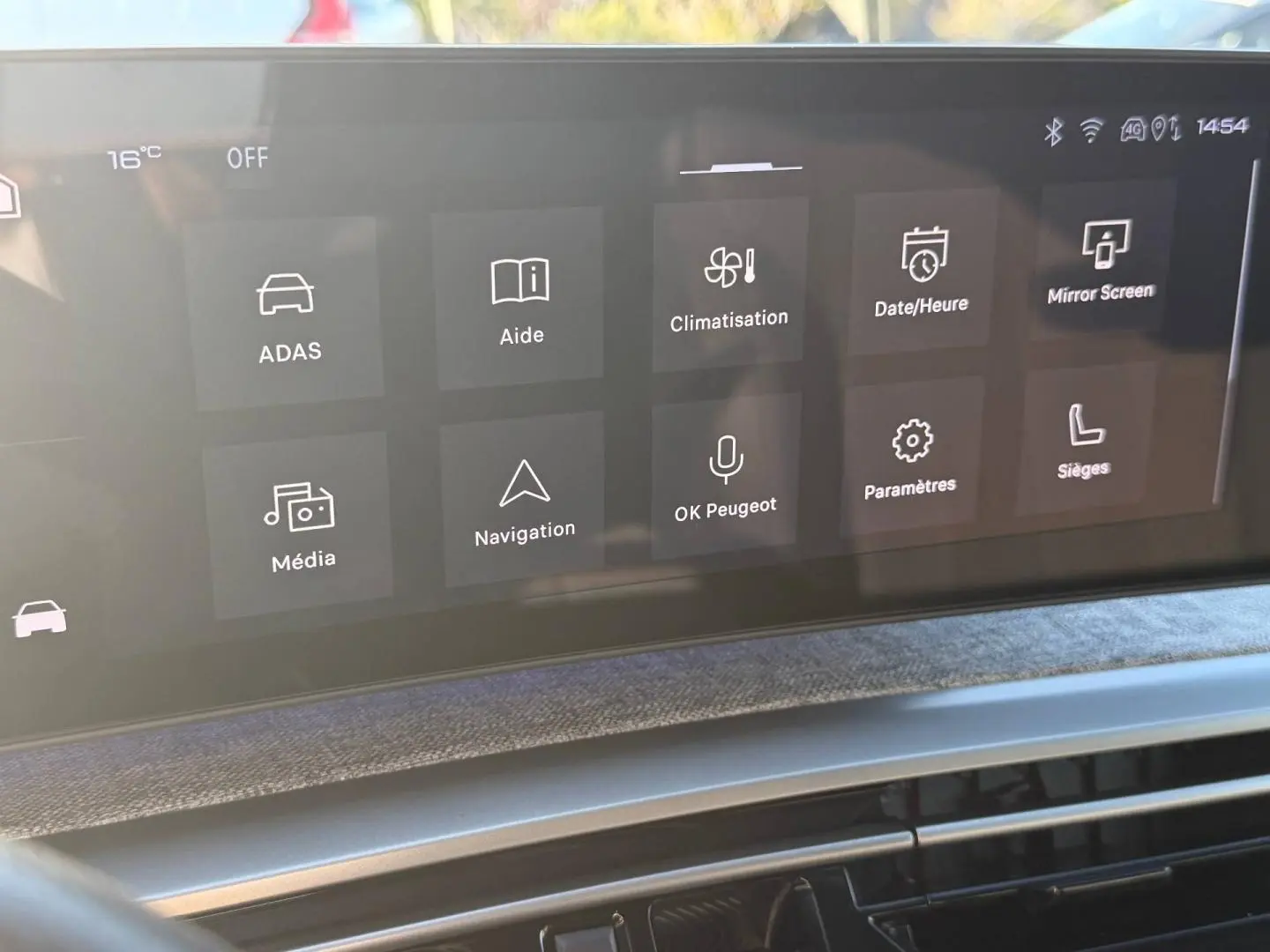 Écran tactile central du tableau de bord du Peugeot 5008 Hybrid blanc, affichant les menus de climatisation et navigation.