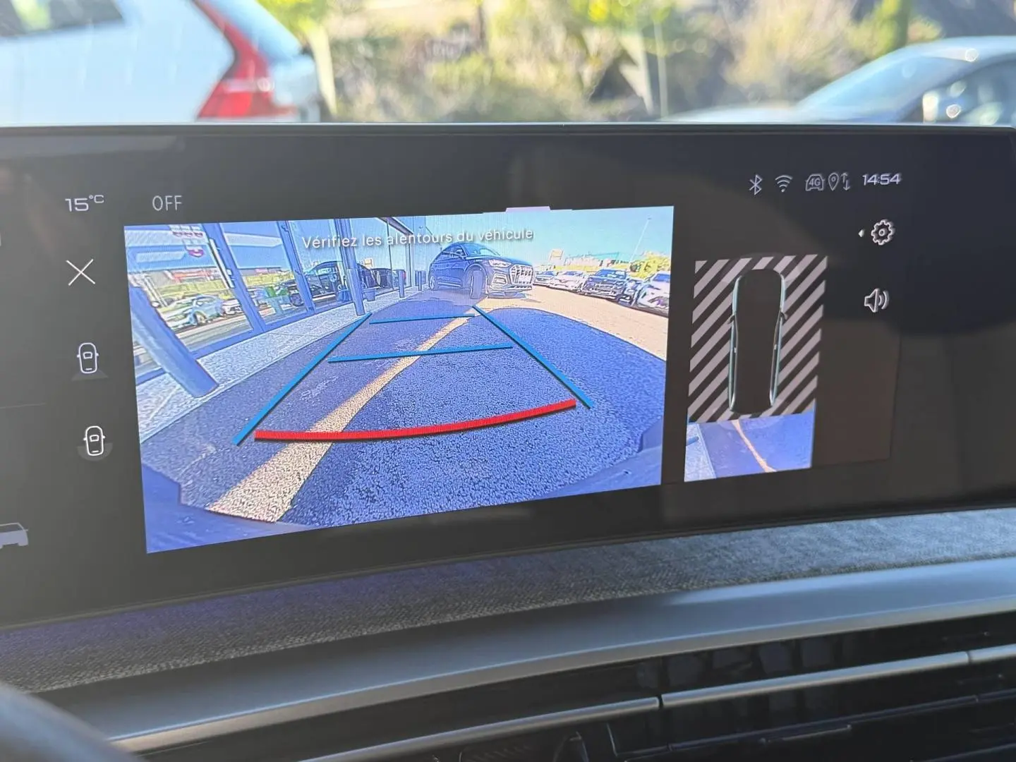 Écran tactile du Peugeot 5008 Hybrid blanc montrant la caméra de recul et l’aide au stationnement en vue arrière.