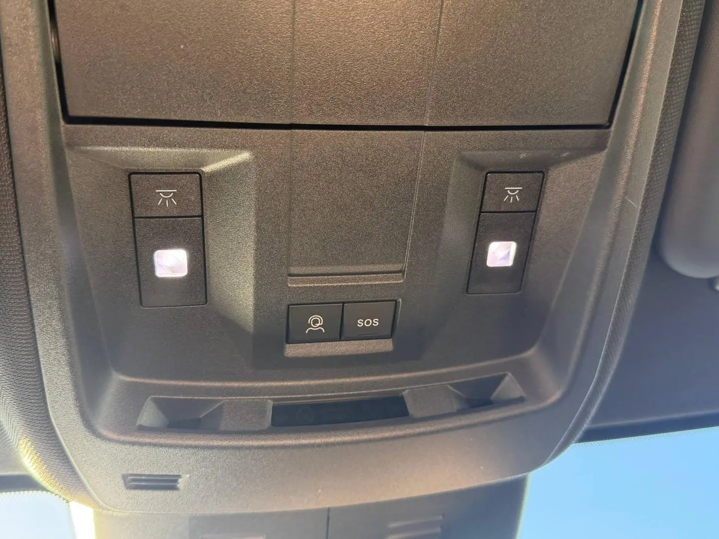 Vue rapprochée du plafonnier intérieur du Peugeot 5008 Hybrid blanc avec boutons d’éclairage et SOS.